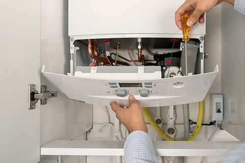 Heating technician repairing a residential boiler in South San Francisco
