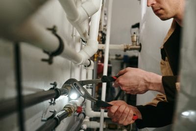 Technician inspecting commercial plumbing pipes in South San Francisco