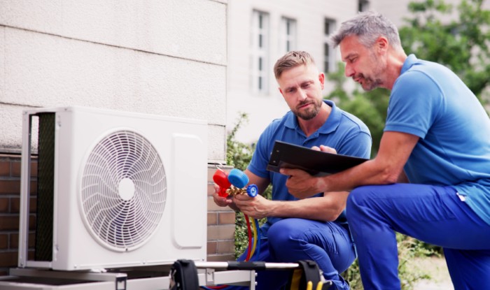 HVAC technicians installing an outdoor air conditioning unit in South San Francisco