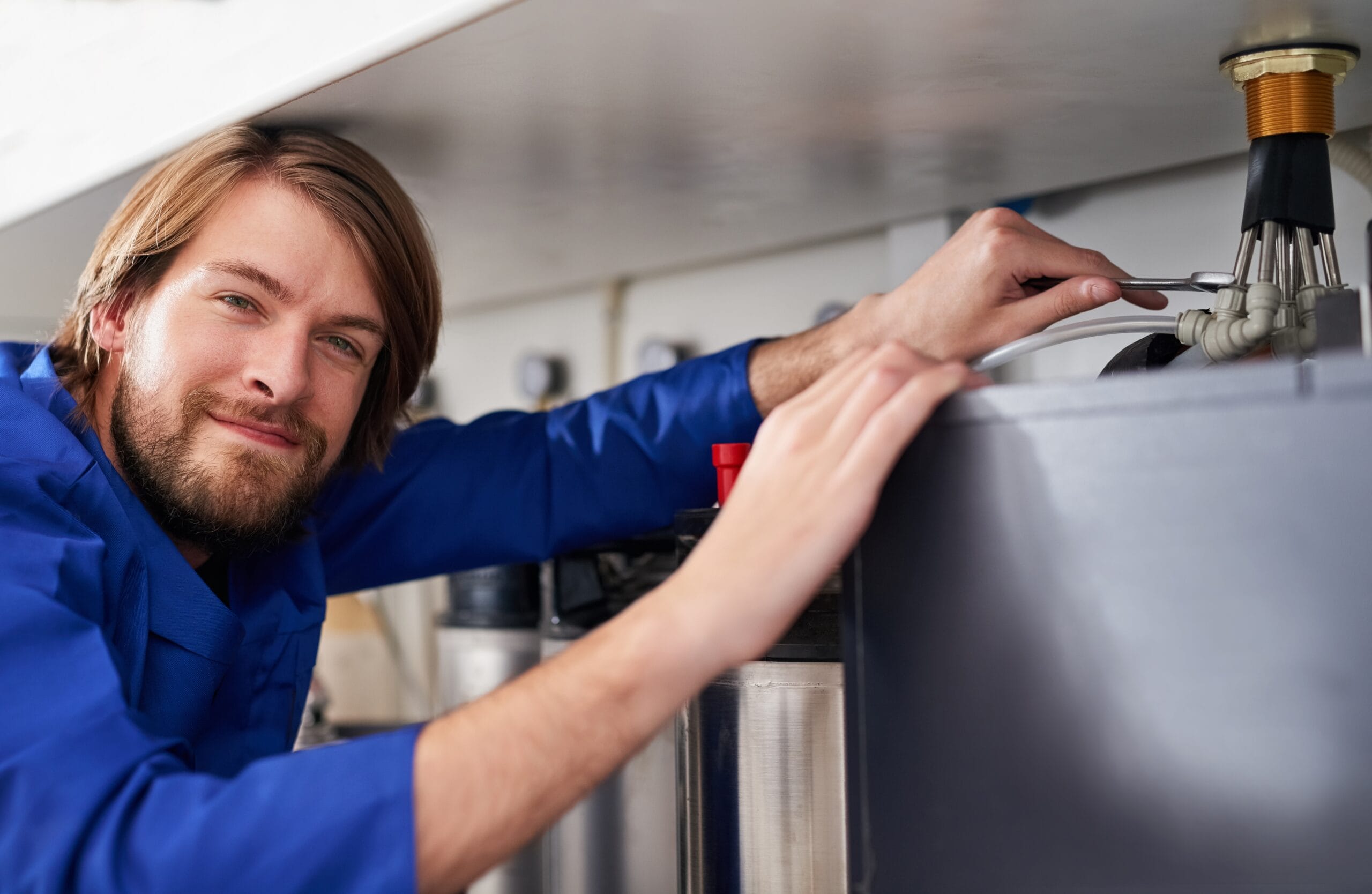 Technician servicing a residential water heater tank in South San Francisco
